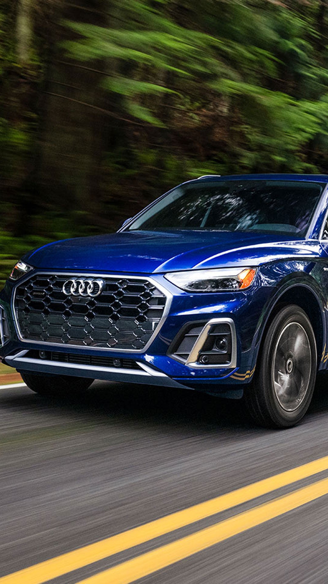 Photo of an Audi e-tron SUV parked near a wall.