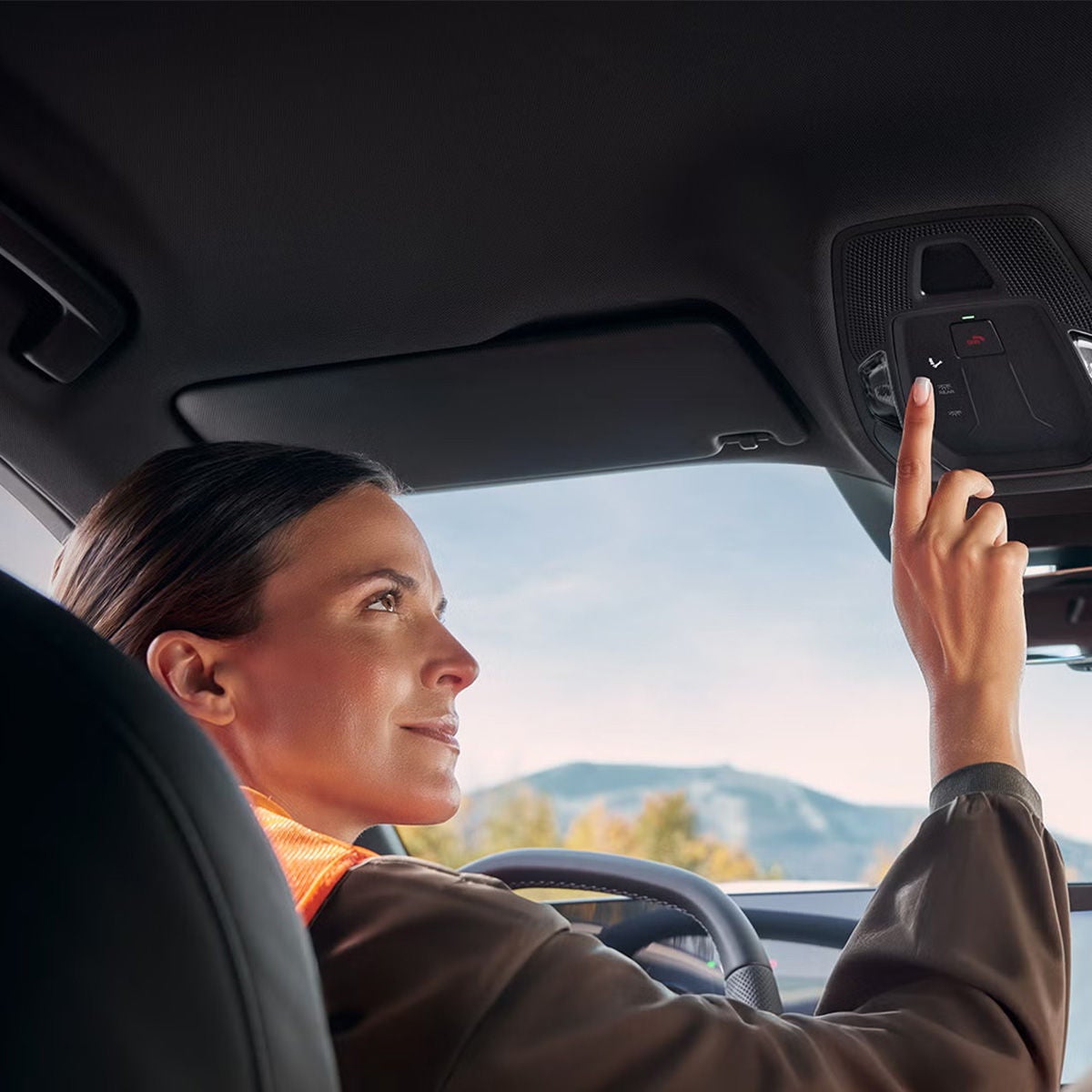 Woman pressing the road side assistance button in her Audi