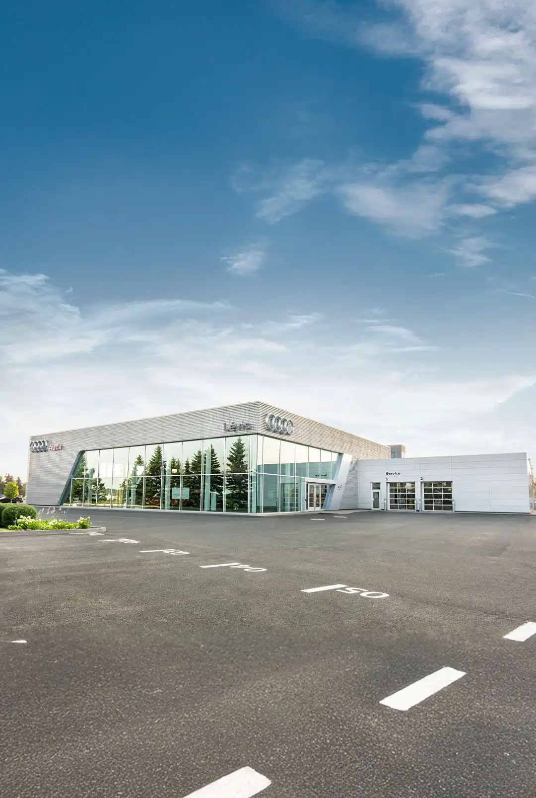 Vue extérieure de la concession Audi Lévis en été.