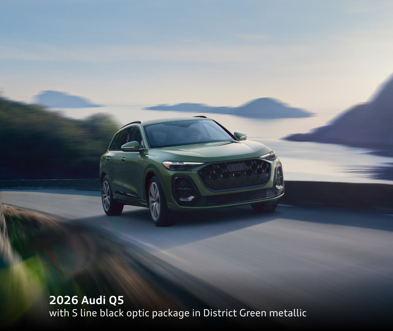 2026 Audi Q5 Prestige TFSI® quattro® S tronic® with S line black optic package in District Green metallic driving through a coastal landscape