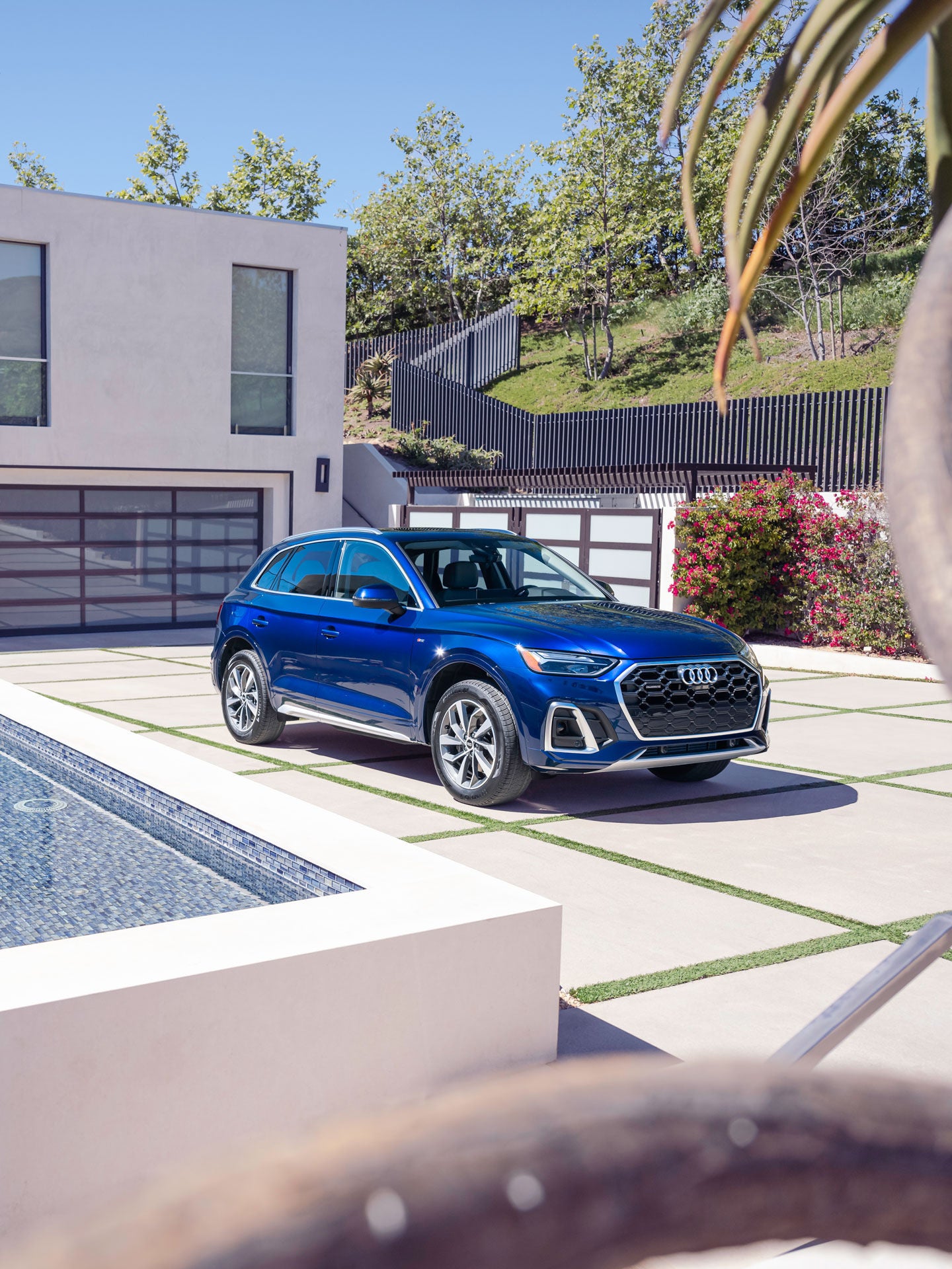 Three-quarter front view of the Audi Q5 parked in front of a modern house.