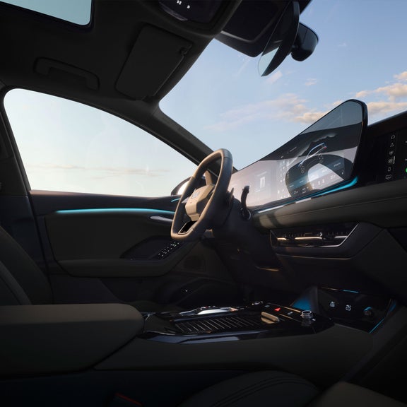 Interior view of the Audi Q6 e-tron, showing the virtual cockpit, MMI display, and driver's seat.