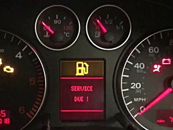 Service technician servicing vehicle with hood open.