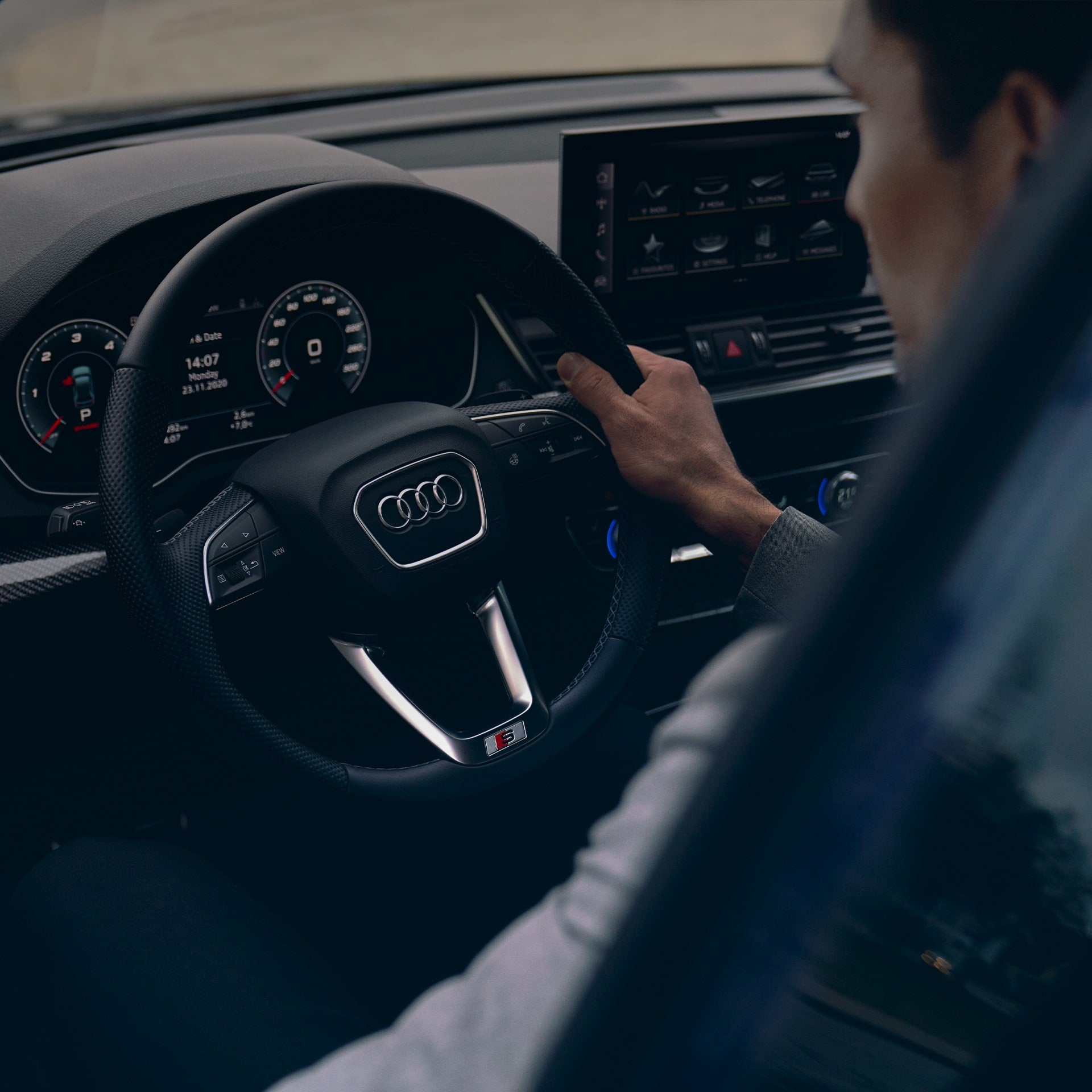 Close-up of a person holding the steering wheel of their Audi.