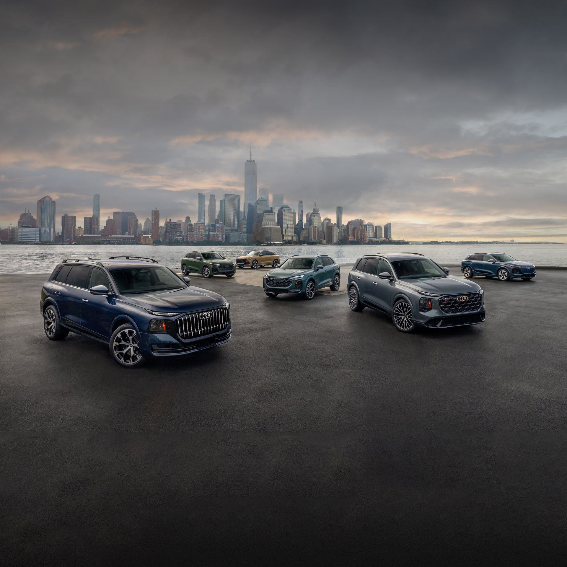 Audi vehicles parked in different positions on a waterfront.