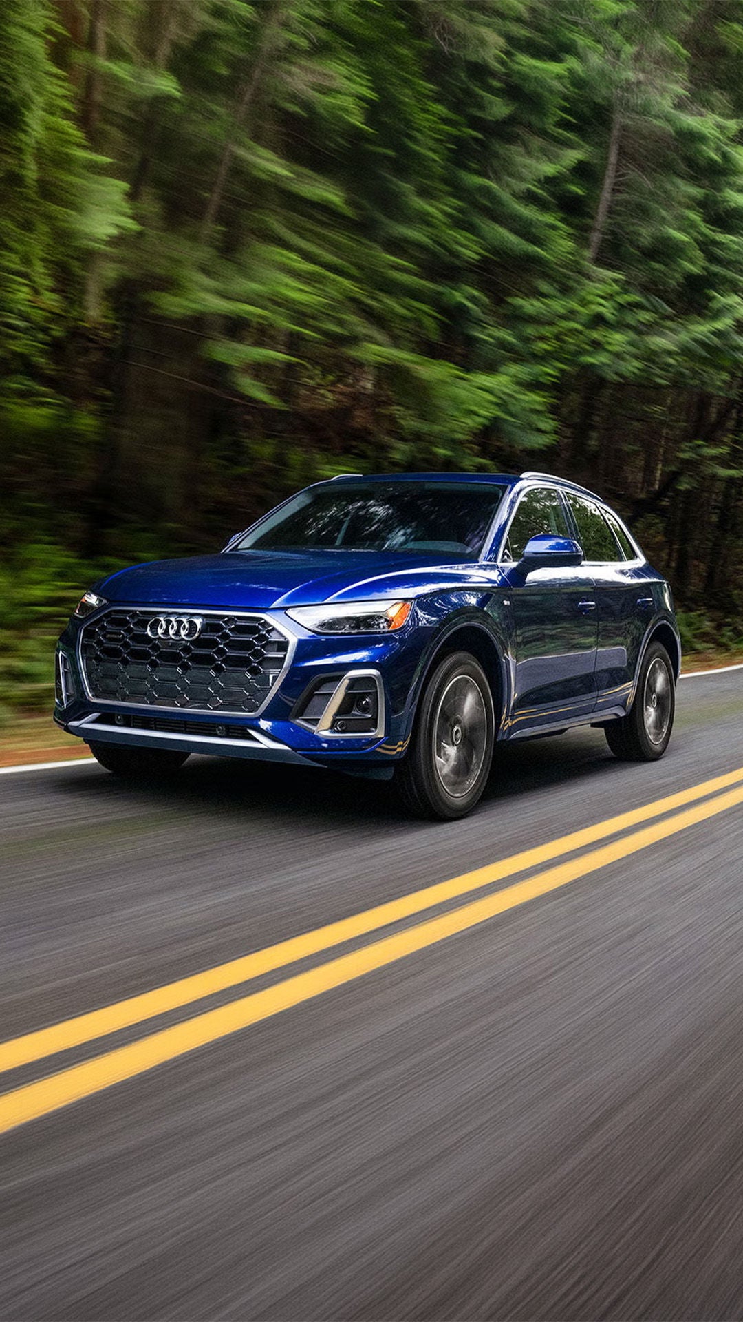 Audi in motion driving down the road