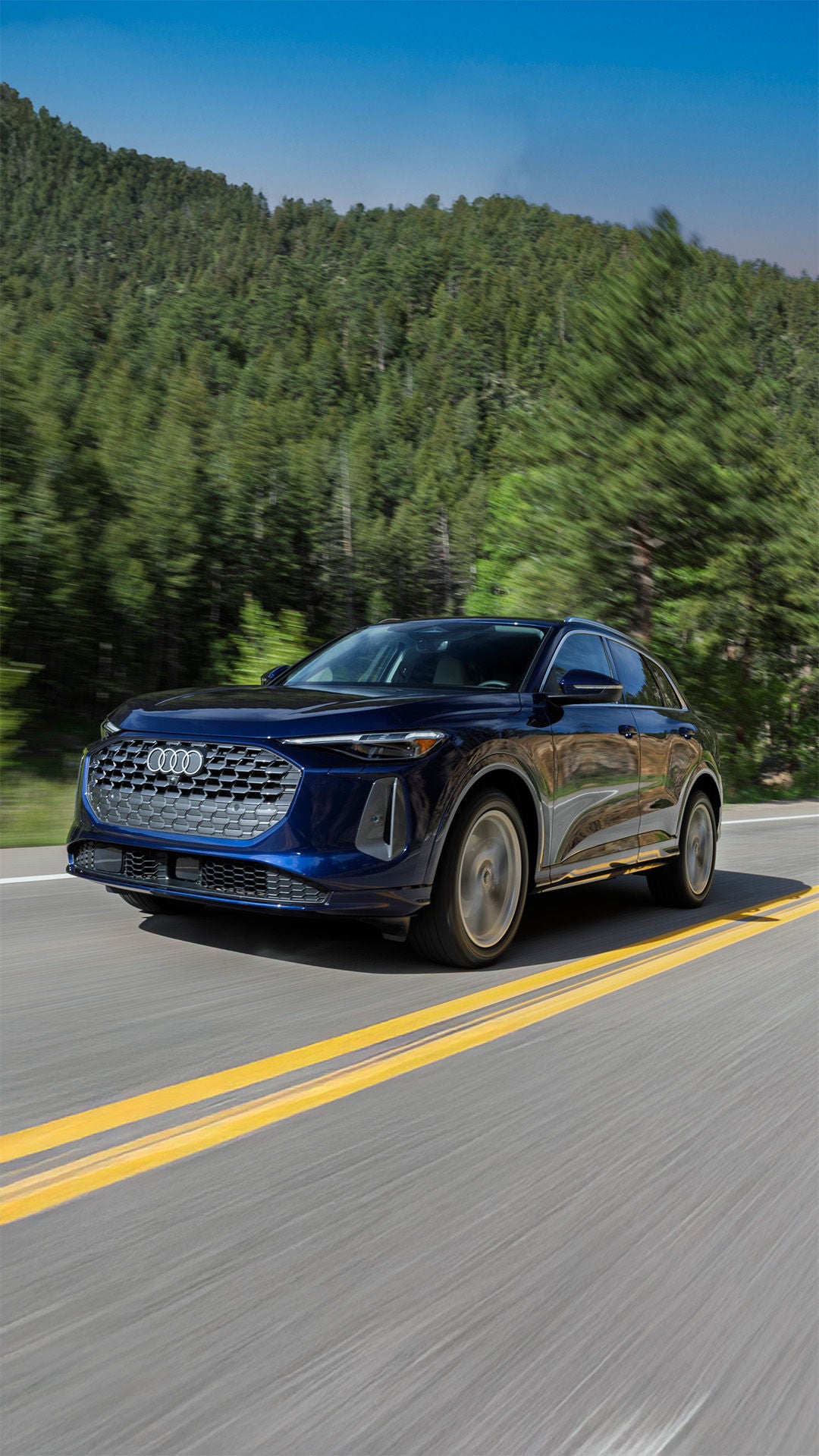 2025 Audi Q5 in blue driving through the mountains