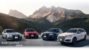 The Audi A4 Sedan, A6 Sedan, Q5 and Q7 parked in front of mountains.