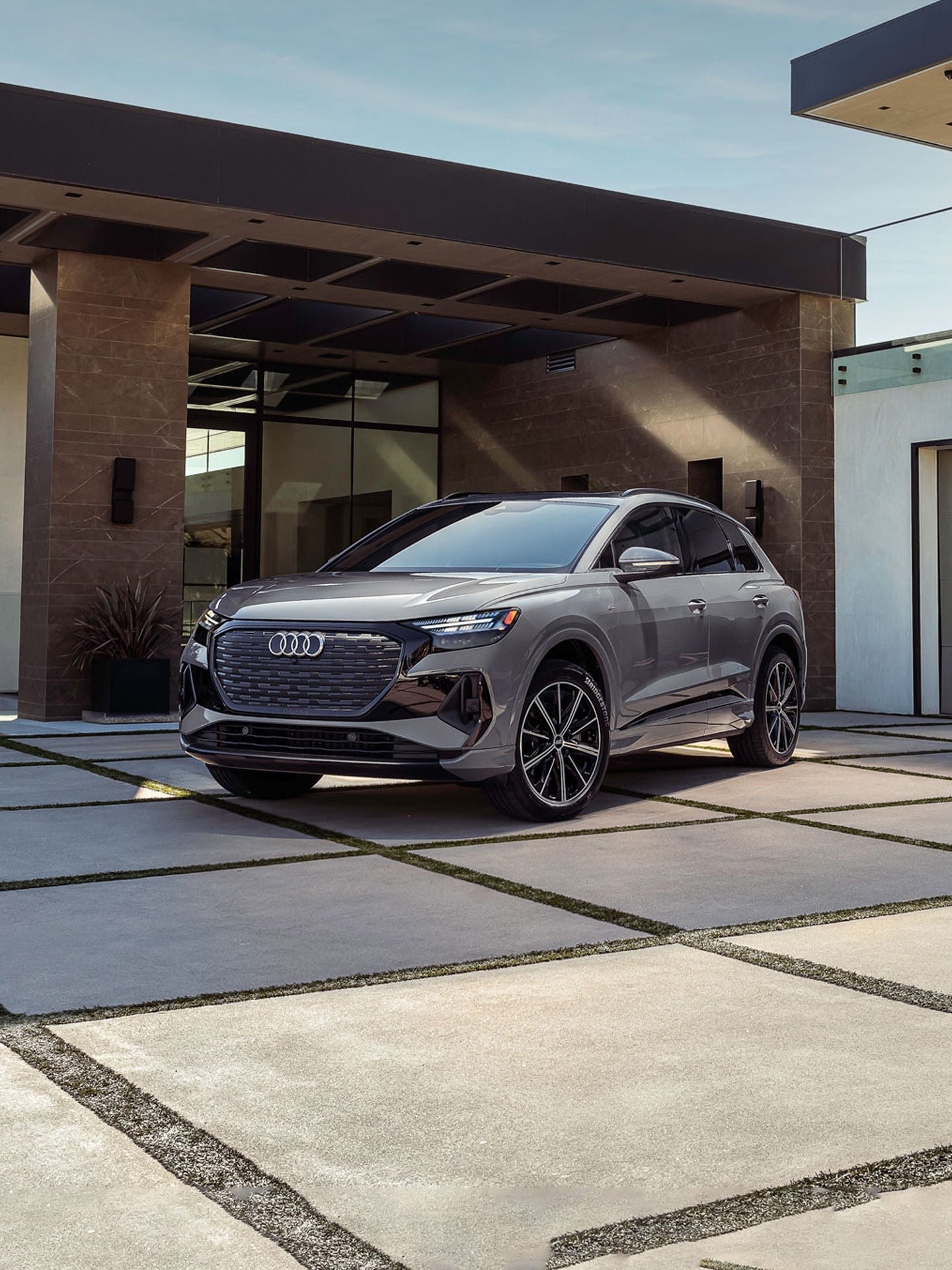 Three-quarter front view of Audi Q4 e-tron in a person's driveway.