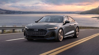 Front view of the Audi A5 accelerating on an oceanside road.