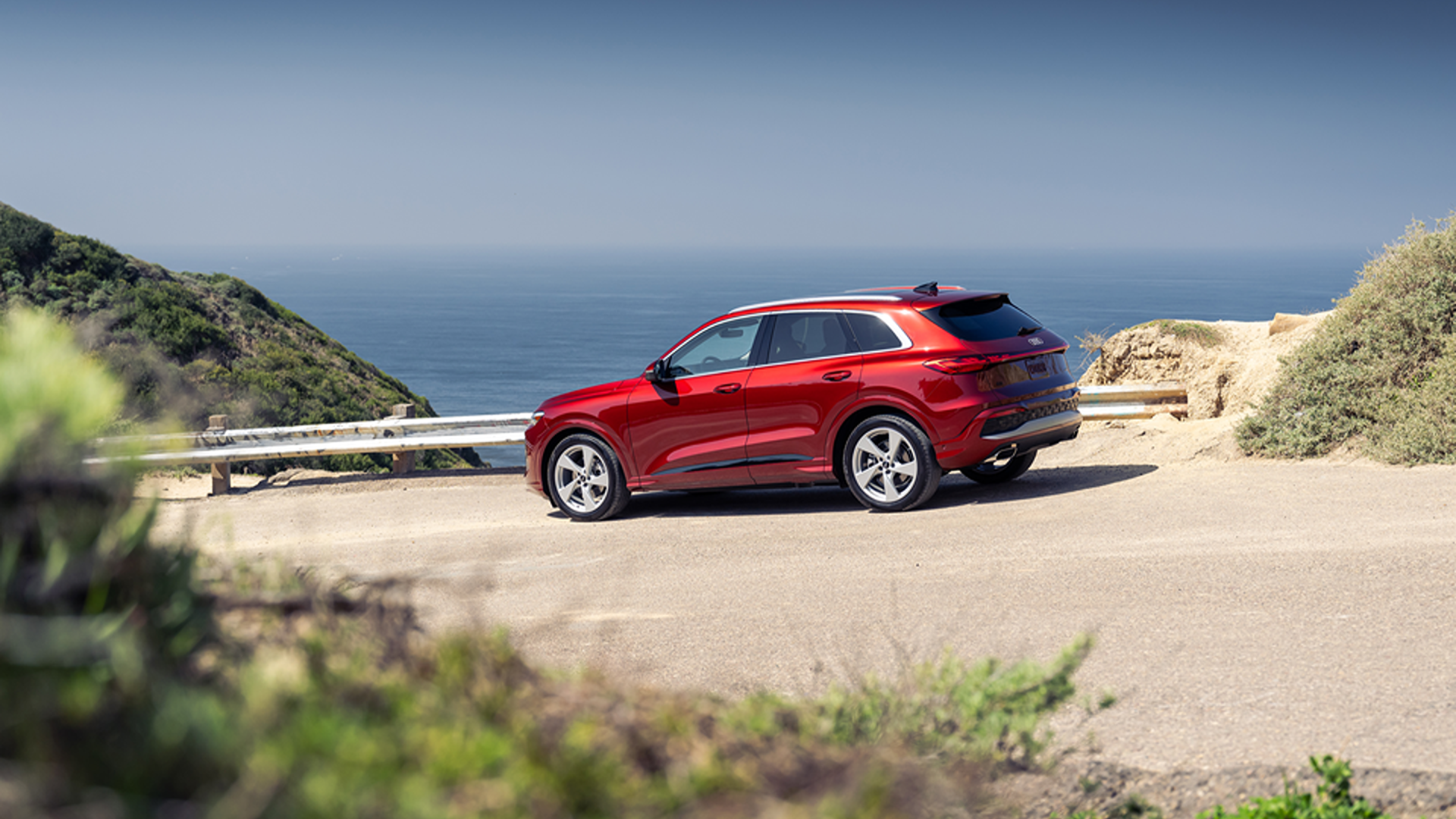 Red Audi Q5 parked near a beach view