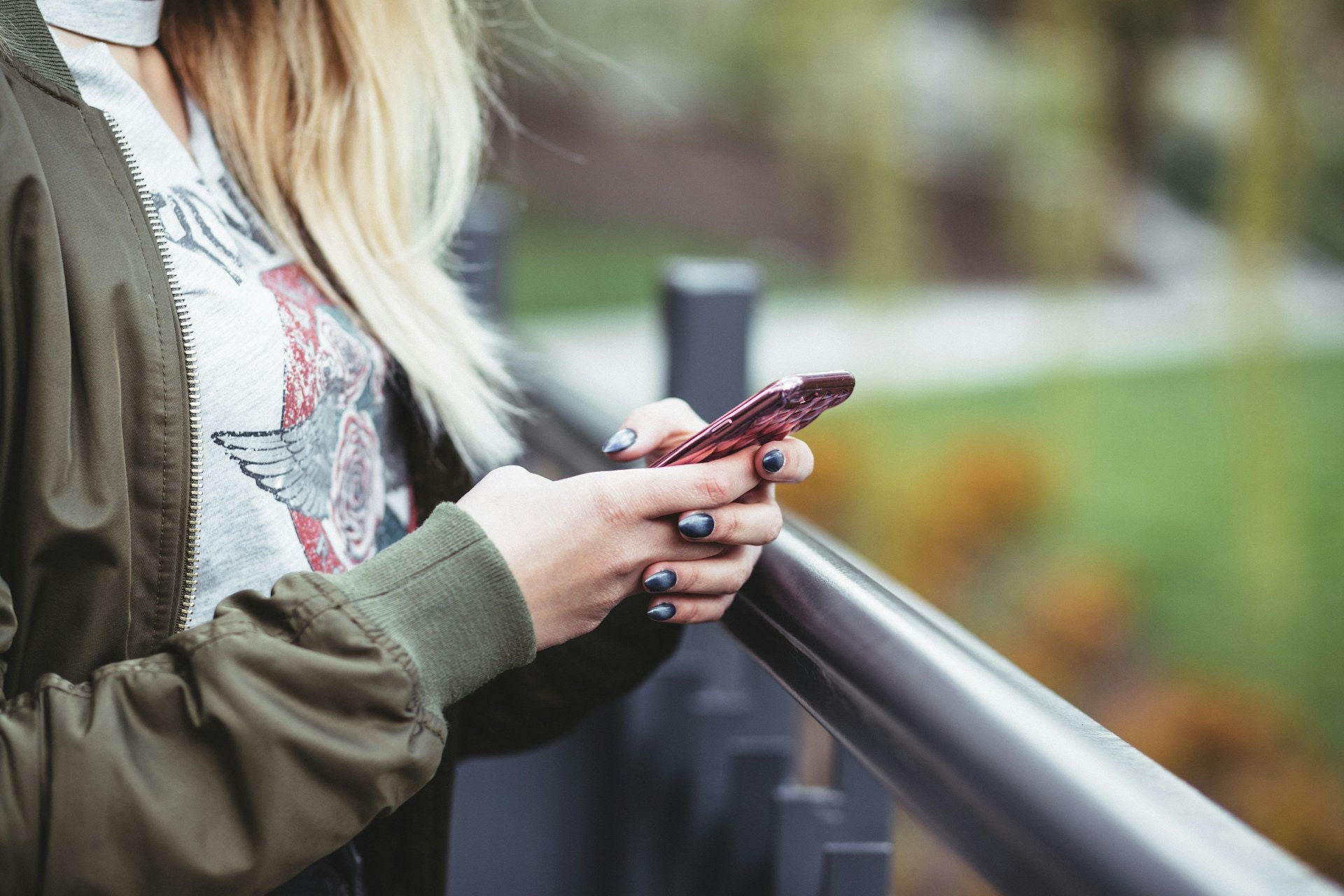 woman looking down at phone to use remote start feature 