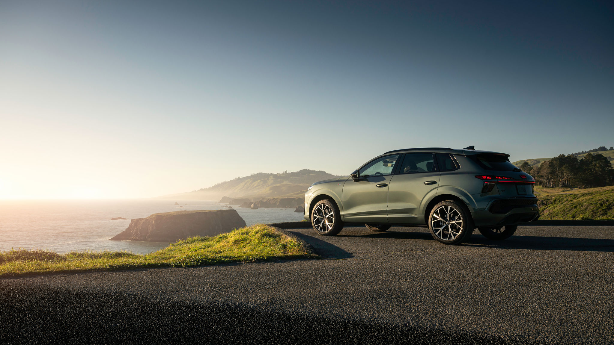 Gray Audi Q3 overlooking the beach, parked on gravel.