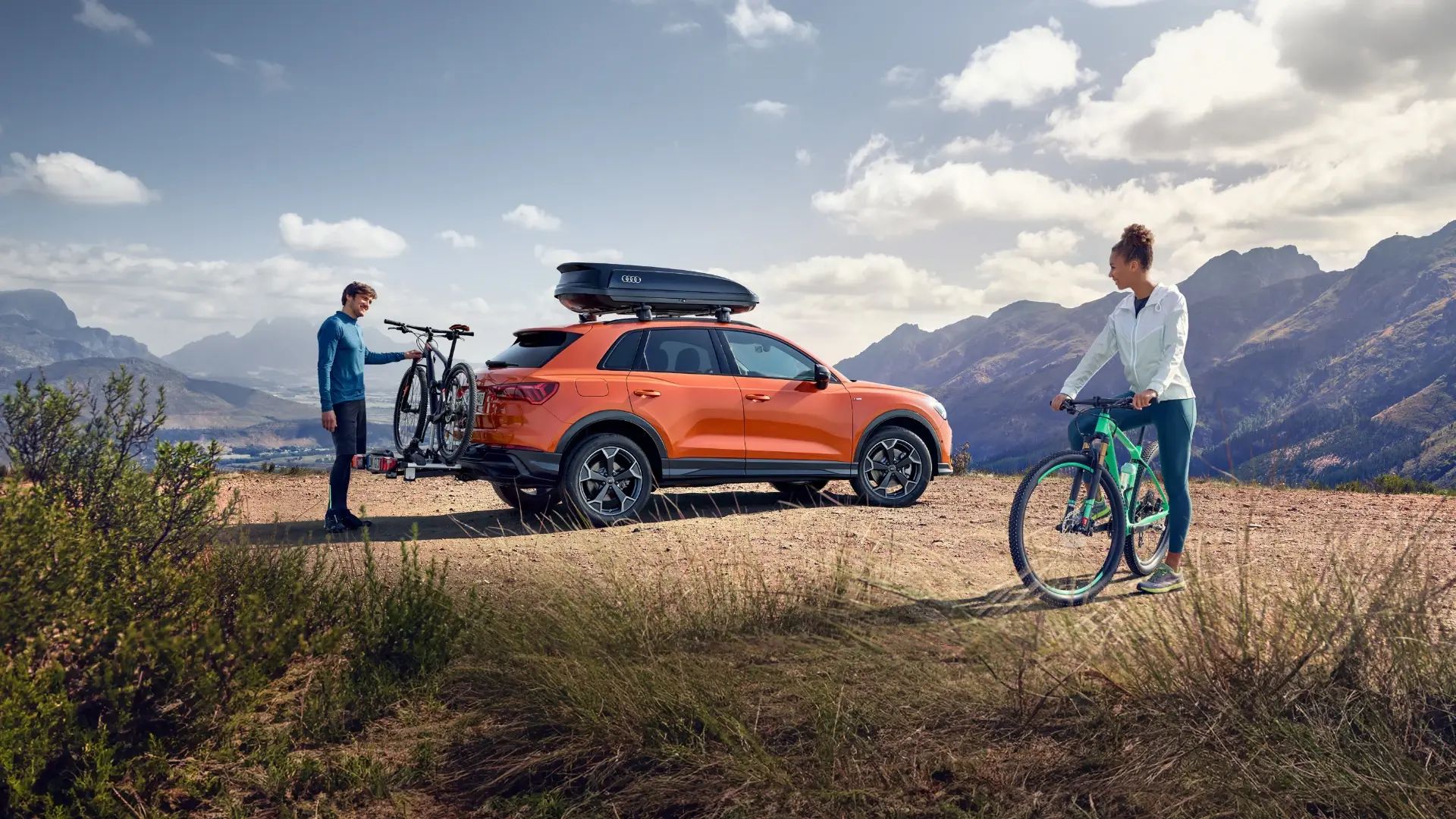 Parked orange Audi with stored bicycles.