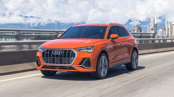 Front view of an Audi vehicle accelerating on a highway.