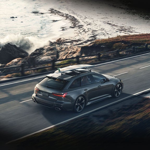 Bird's eye view of an Audi RS 6 Avant driving down a coastal road.