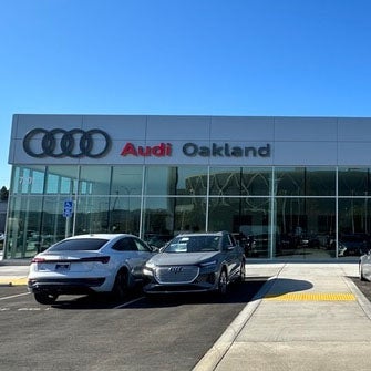 Audi Oakland entrance with signage and parked vehicles