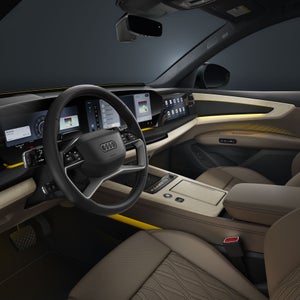 A view of the Q9 SUV's cockpit from the driver's side. The interior is bathed in a yellowish ambient light.