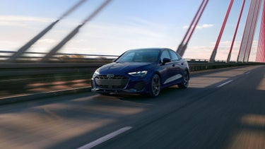 Three quarter front view of the Audi A3 accelerating on a bridge.