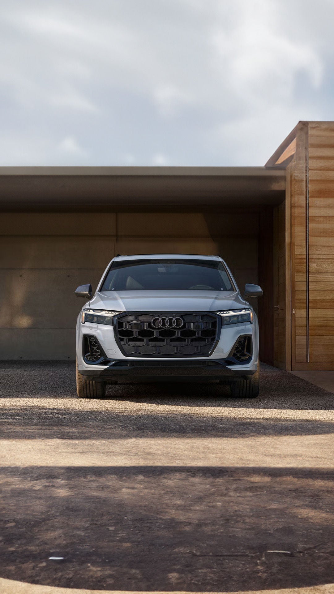 Front view of an Audi in front of a modern house