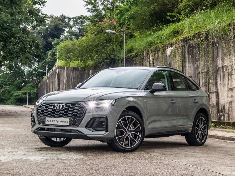 Silver Audi Sedan driving down the highway as the sun sets