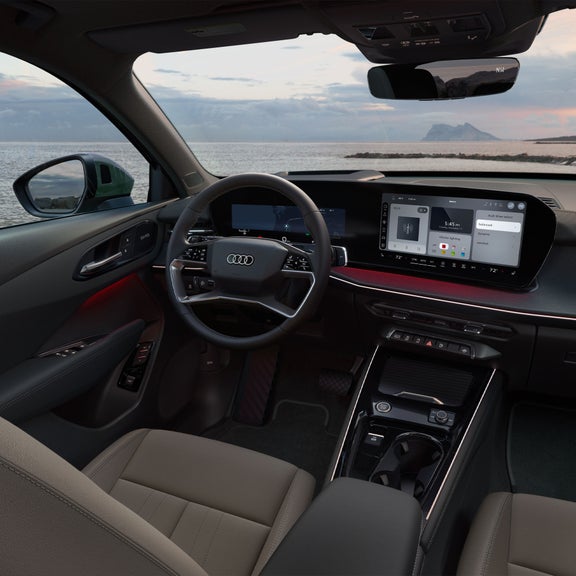 Vue du poste de conduite de l'Audi Q3, montrant les sièges en cuir, les volants et la console centrale.