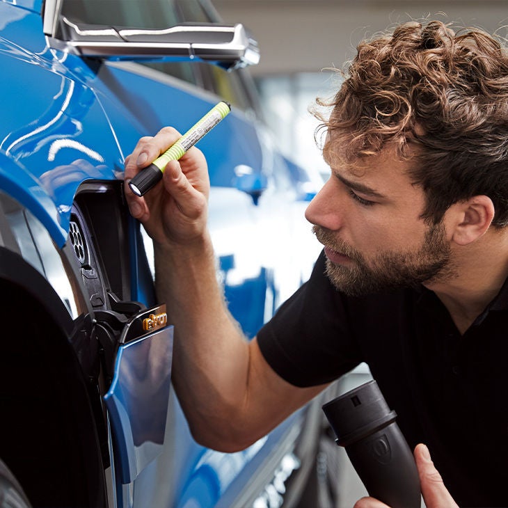 An Audi Technician inspecting the charging port on an Audi e-tron.