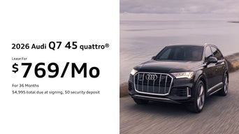 Front left view of a white Audi Q7 parked.