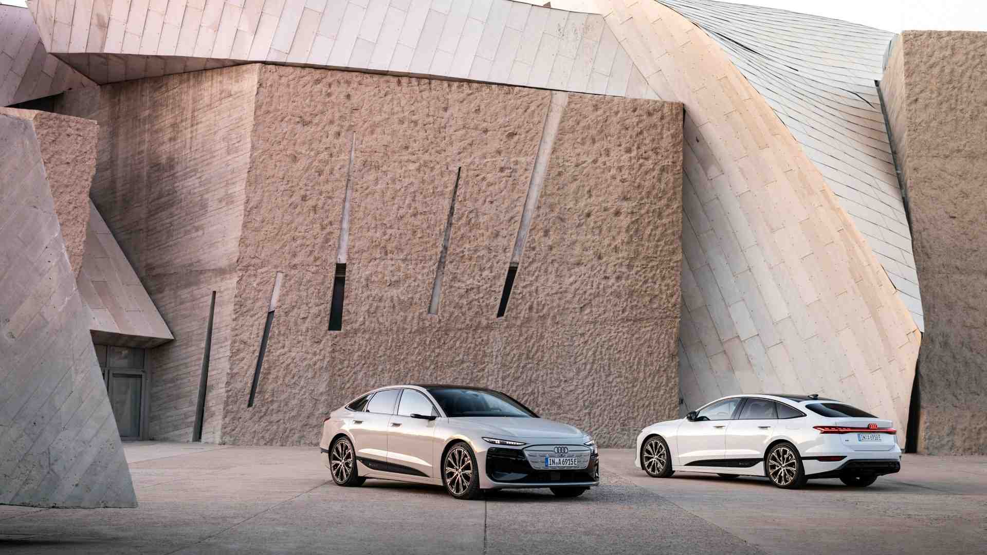 Side profile view of two audi sportsback vehicles parked.