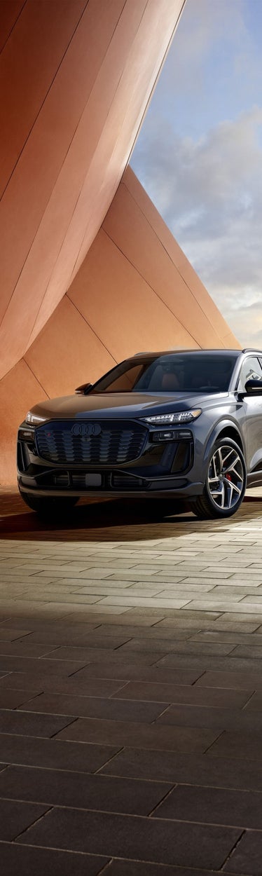 The 2027 SQ6 e-tron charging on a high level parking spot.