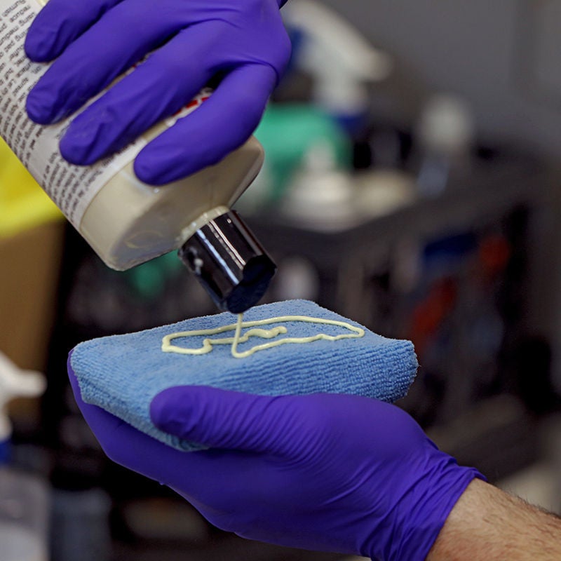 Image of a detailers hands putting wax on a sponge