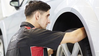 Service technician servicing tire.
