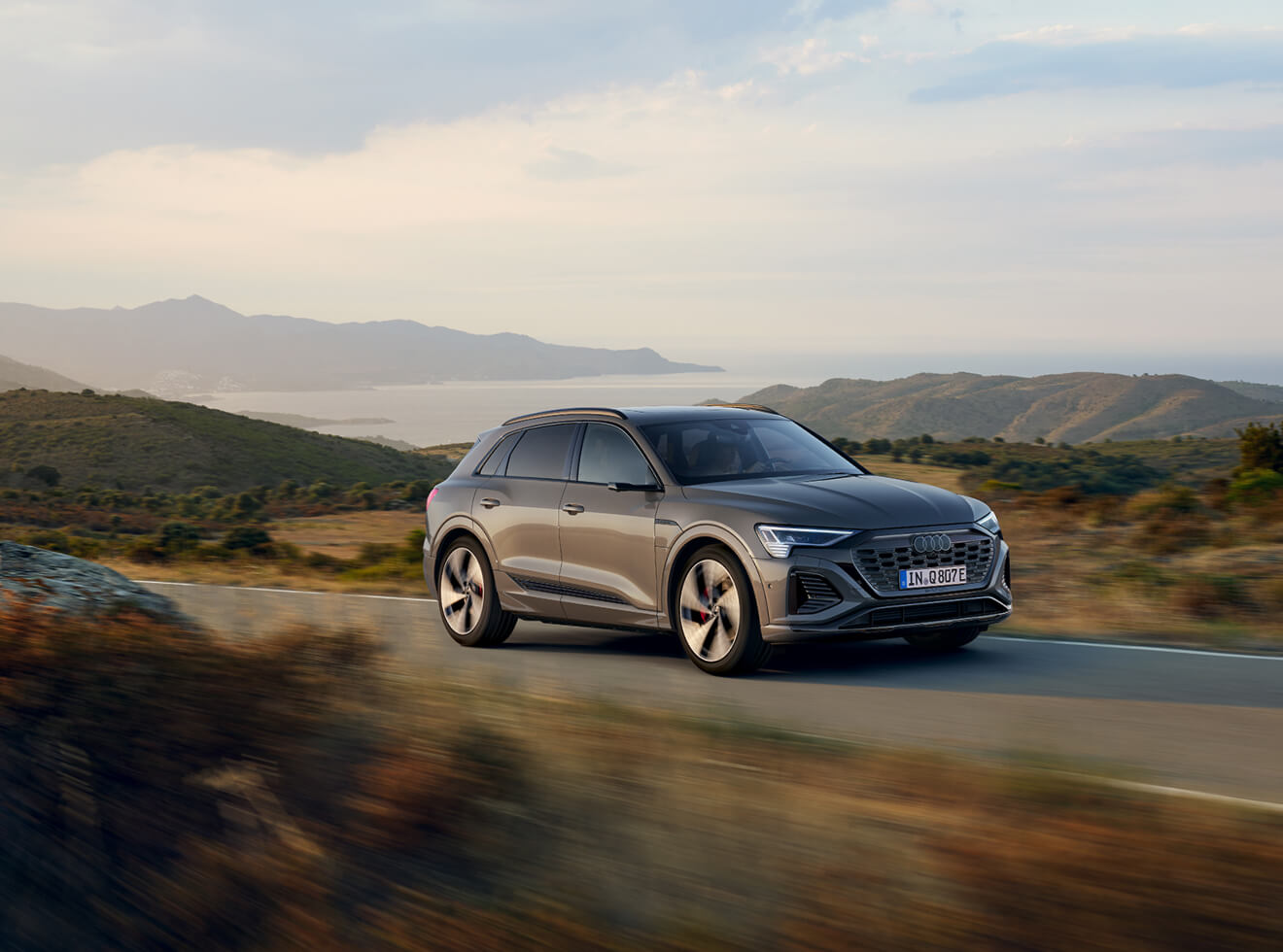 Gray Audi SUV driving on a scenic road
