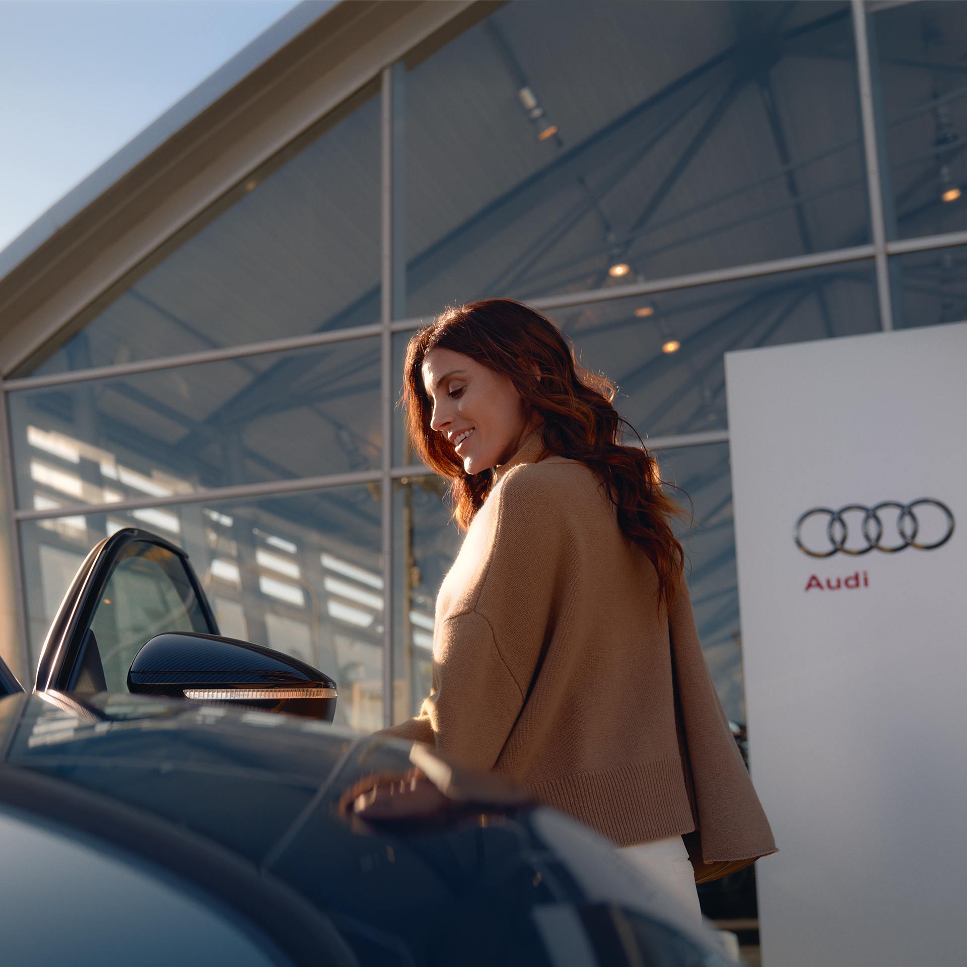 Un client Audi ouvre la portière côté conducteur de sa voiture.