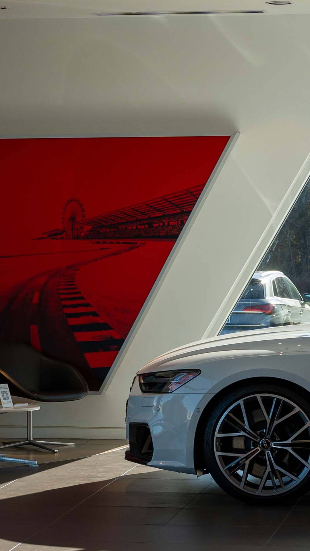 Left profile view of an Audi vehicle parked in the showroom.