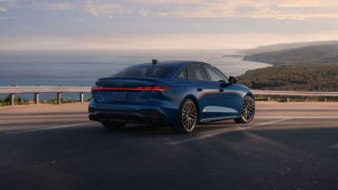 Three-quarter rear view of the Audi S5 accelerating on an oceanside road.