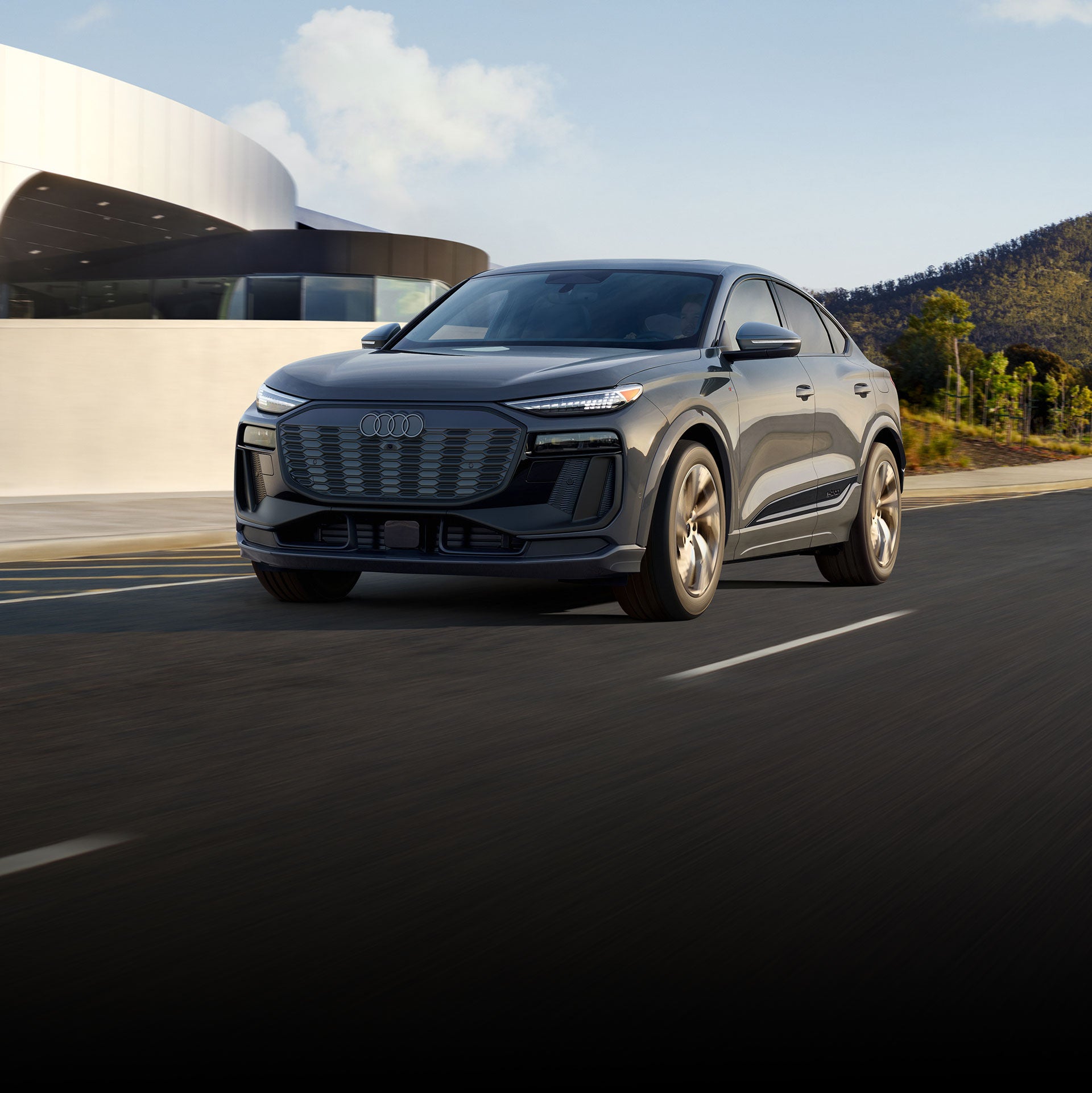 Three-quarter front view of the Audi Q6 Sportback e-tron in motion.