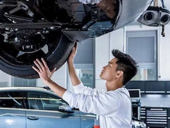 Service technician serving vehicle.