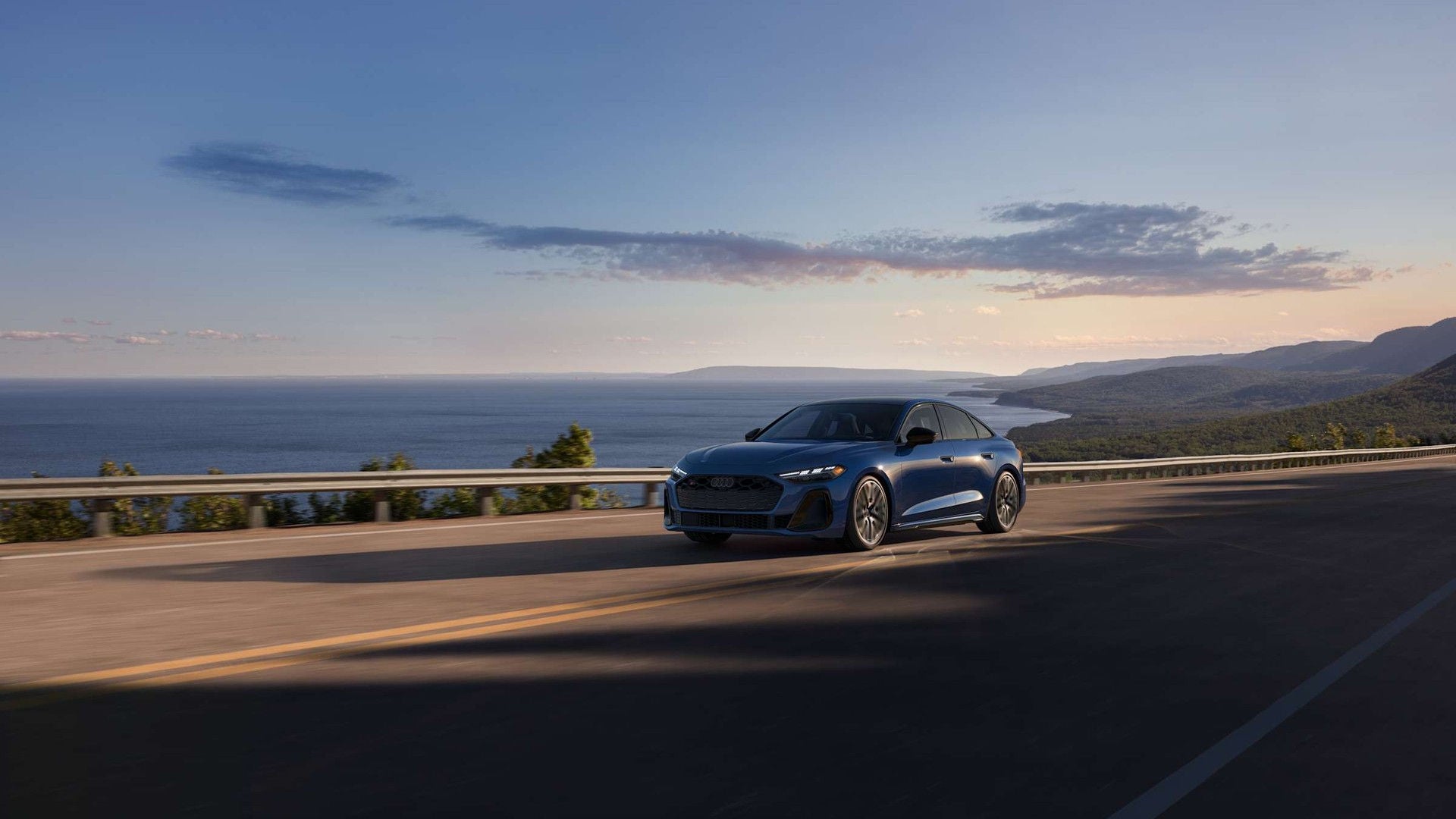 2026 Audi S5 in Ascari Blue driving on a coastal road.