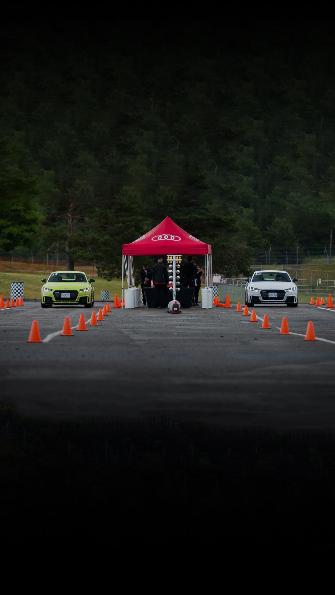 Vue de face de deux véhicules Audi garés sur une piste de course.