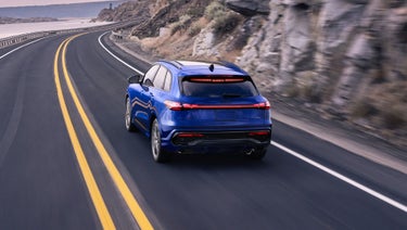 Rear view of the Audi Q5 accelerating in a mountainous landscape.