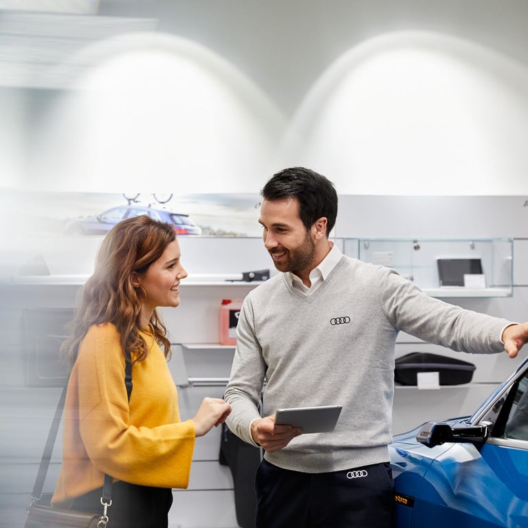 Employé d’Audi expliquant le Programme des nouveaux arrivants d’Audi Finance à un client.