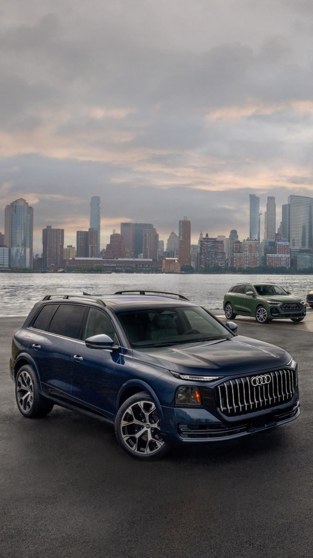 Lineup of Audi SUV models across a city skyline.