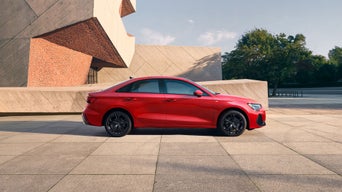 Audi sedan parked in front of luxury building