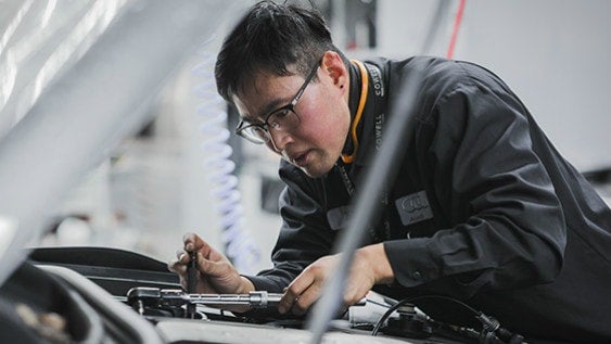 An Audi technician working on a vehicle.