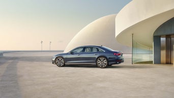 Side-view of the Audi A8 parked by a modern building.