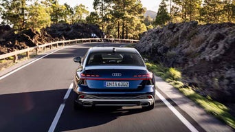 Back view of the 2026 Audi A6 Sedan driving on the road.