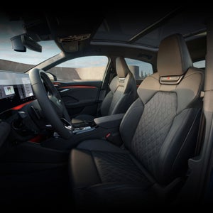 Interior view of the driver's cockpit in the Audi SQ6 Sportback e-tron, showing the front sport seats.