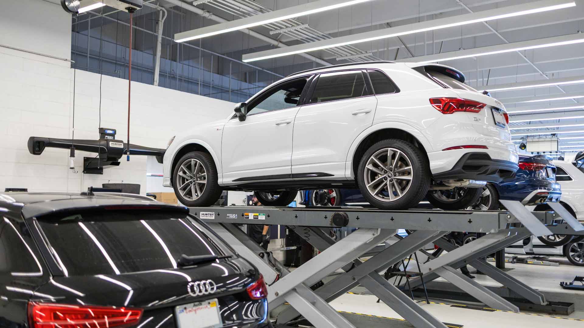 Audi service technician servicing a vehicle.