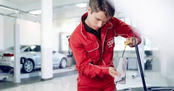 Service technician servicing vehicle.